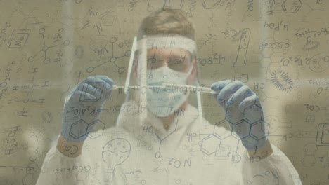 animation of medical data processing over caucasian man in face mask and ppe suit holding swabs