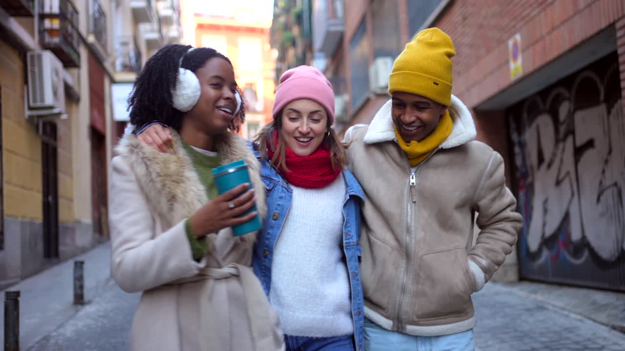 Three friends walking in the city in winter