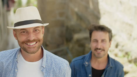 portrait of gay couple standing on stairs outdoor and dancing while look at the camera