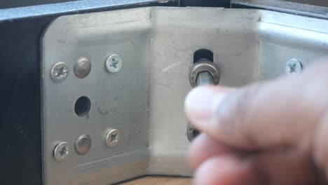 persona que utiliza un destornillador para apretar un tornillo en un mueble