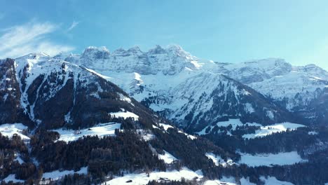 Amazing-drone-flight-of-a-stunning-alpine-valley,-village-and-snow-covered-mountain-peaks-in-Champery,-Switzerland