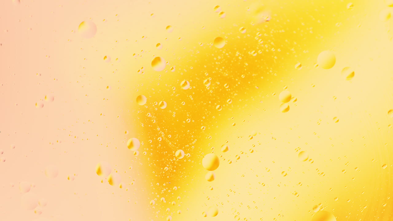 Primo piano ravvicinato di bolle d'olio in rotazione nell'acqua con sfondo astratto di miscelazione a gradiente di colore