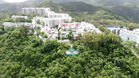 templo clásico en hong kong, rodeado de un exuberante terreno montañoso verde, vista aérea