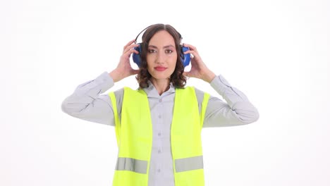 woman wearing safety earmuffs and high-visibility vest