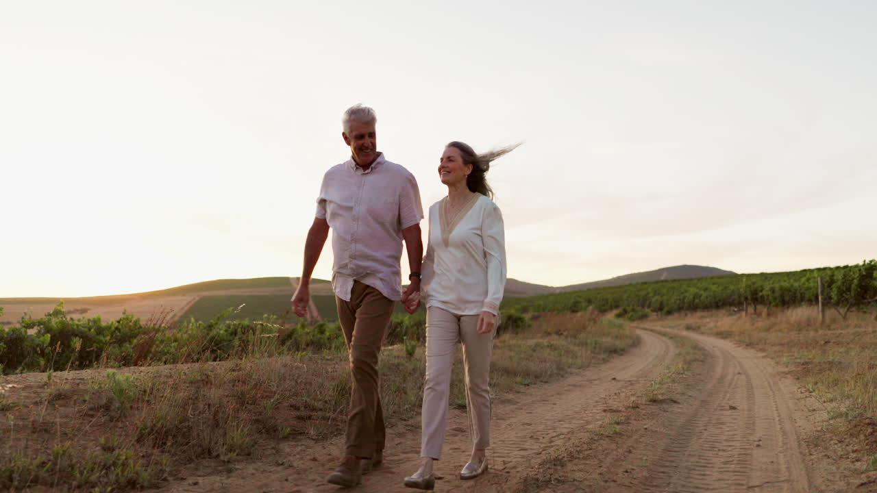 una pareja mayor disfrutando de un paseo panorámico en un viñedo al atardecer