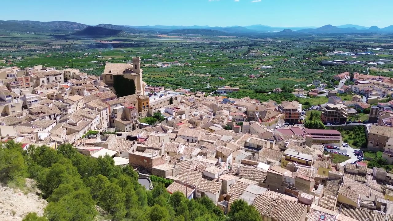 Vista aerea con drone della storica città di Calasparra nel sud della Spagna, con case del centro storico, castello medievale, paesaggio montano, architettura tradizionale, destinazione di viaggio e un panoramico panorama urbano.