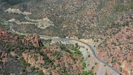 aerial view of traffic on arizona state route 89a in desert valley landscape near jerome old mining town, drone shot