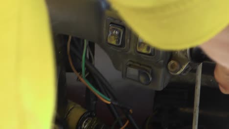 vista interior de un tradicional mototaxi cubano amarillo mientras conduce por la famosa carretera oceánica llamada malecón en la habana, toma de primer plano del salpicadero, los cables y las manos del conductor