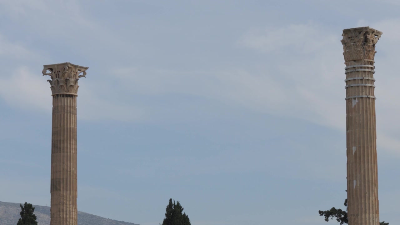 Ripresa dinamica in tilt-up che rivela le antiche colonne del maestoso Tempio di Zeus Olimpio ad Atene, Grecia