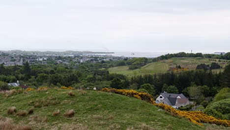 Wide-shot-of-the-small,-port-village-of-Stornoway-and-the-houses-and-landscape-surrounding-it