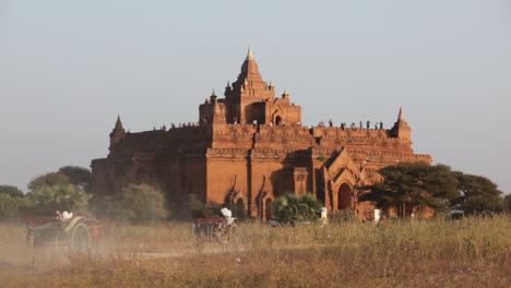 busses approach the stone temple on the plains of pagan bagan burma myanmar