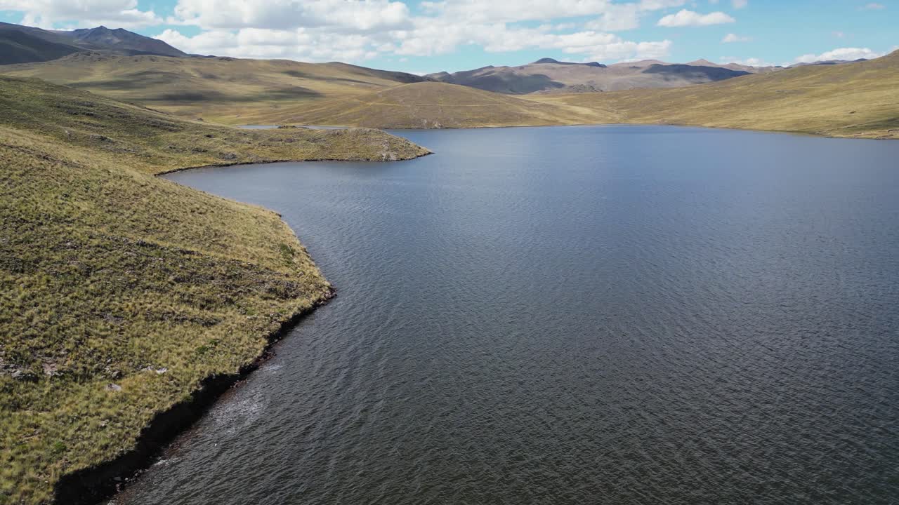 Low flyover of grassy shoreline of Lake Lagunillas in arid south Peru