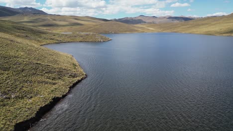 low flyover of grassy shoreline of lake lagunillas in arid south peru