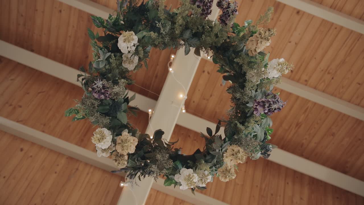 Slow motion shot of a floral wedding wreath gently blowing in the wind