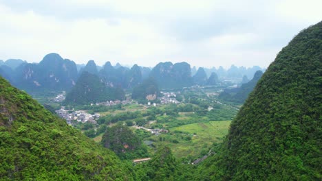 Vista-Aérea-Panorámica-De-Un-Pueblo-En-Yangshuo-Entre-Las-Montañas,-China