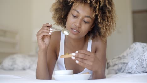 mujer disfrutando del desayuno en la cama