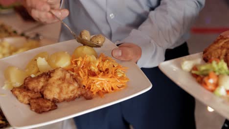 a-man-and-a-woman-fill-their-plates-with-various-delicacies-from-the-buffet