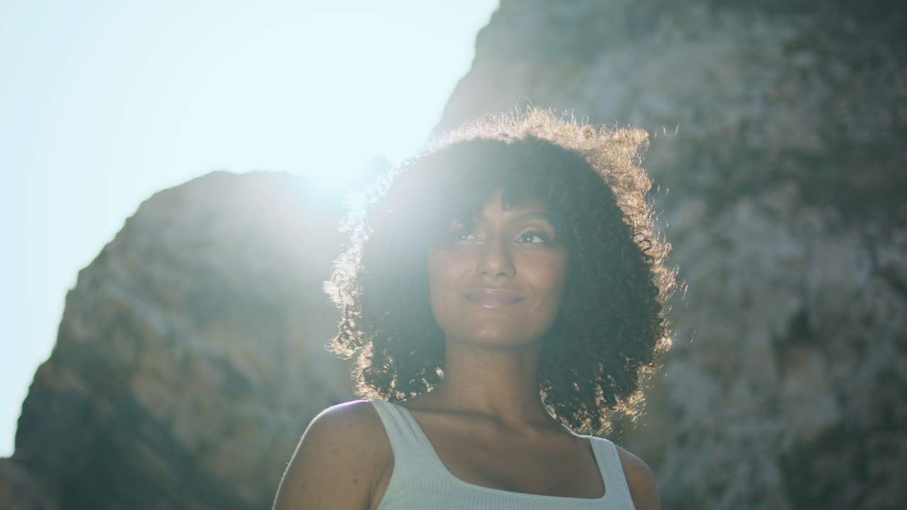 Smiling african woman standing beach lighted sunlight close up vertical view