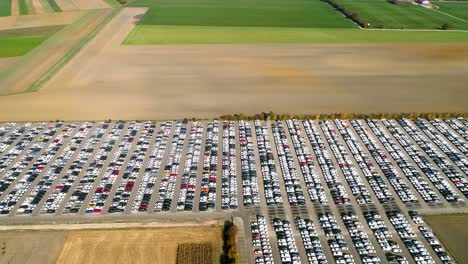 Aerial-footage-of-finished-cars-ready-to-be-shipped-on-huge-distribution-center