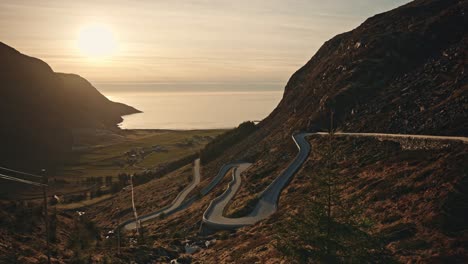 Winding-road-of-Hoddevik-during-golden-sunset,-aerial-view