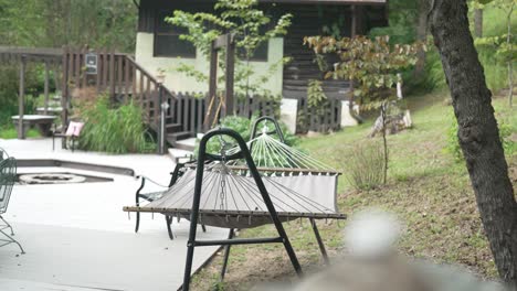 This-stock-video-footage-captures-a-serene-scene-of-a-hammock-gently-swaying-in-the-breeze,-providing-a-calming-and-relaxing-atmosphere