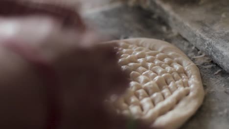 closeup of naan being kneaded, oven baked flat bread.