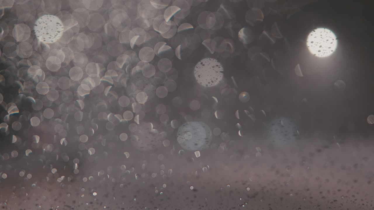 밤에는 도시 조명과 함께 흐릿한 도시 풍경, 흐릿한 배경, 도로에서 기계를 타고, 도시에서 눈이 내리고, 차 앞 유리 기기는 창문에서 눈을 청소합니다.