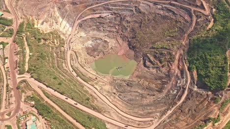 una amplia toma aérea de drones de caminos de tierra que serpentean alrededor de la cantera principal de la mina de oro y plata de siana, temat, filipinas