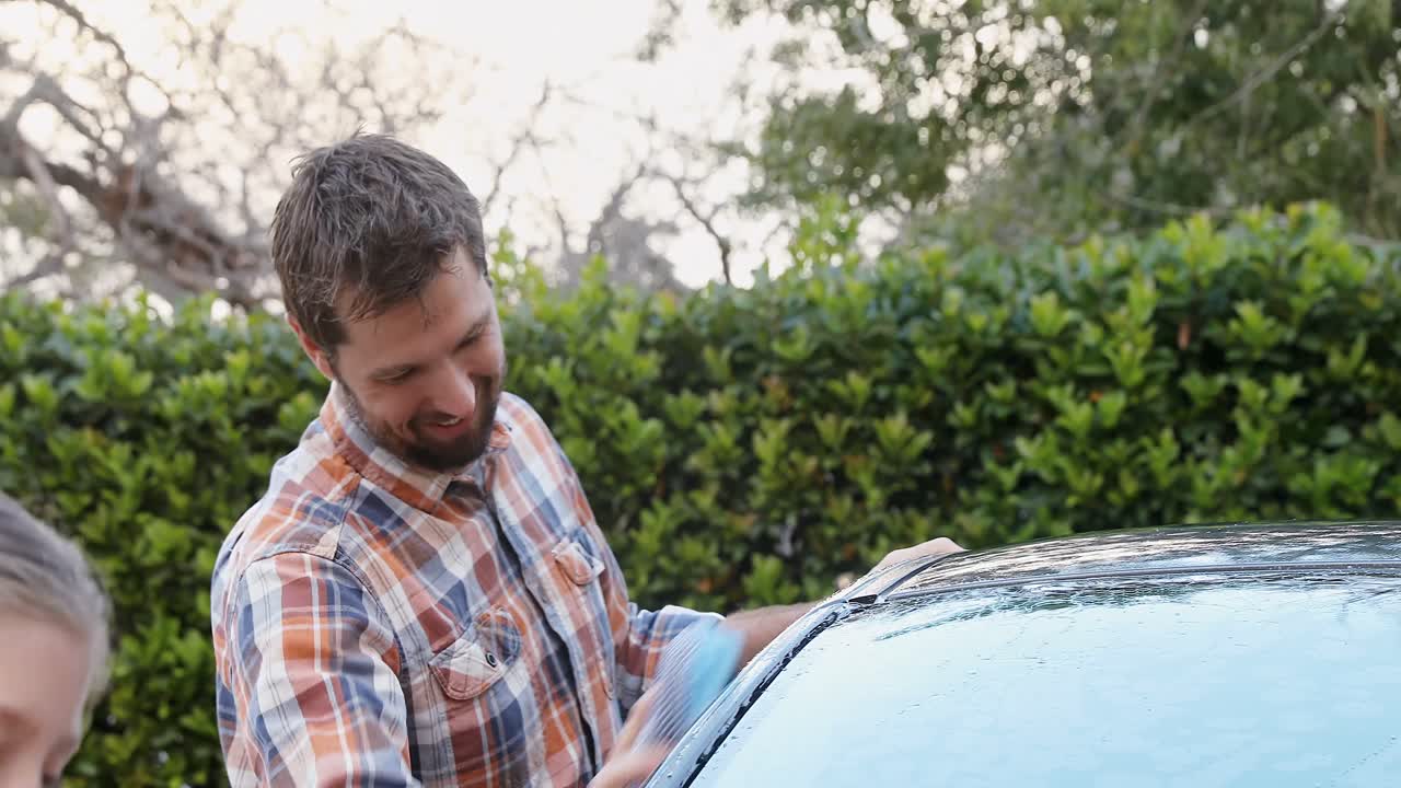hija feliz y padre lavando el coche con esponja 4k 4k