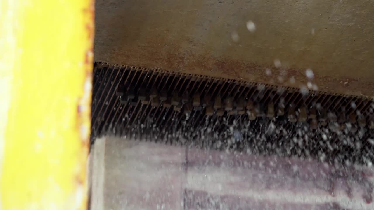 Ampia inquadratura del taglio di un blocco di marmo con sega a filo diamantato raffreddata ad acqua in una fabbrica industriale di marmo. Processo di taglio a umido, macchinari di precisione, produzione di lastre di marmo, lavorazione di granito e marmo.