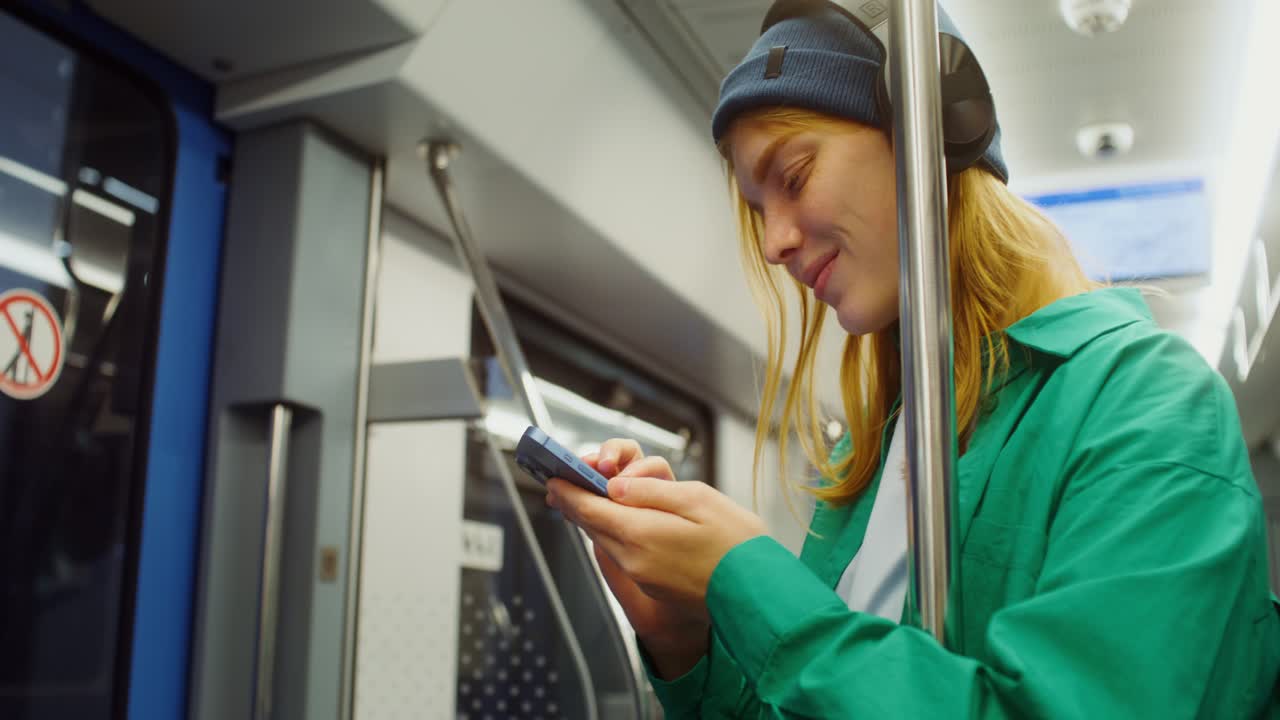 Woman with Headphones Using Smartphone on Subway Train