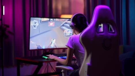 una adolescente asiática pierde mientras juega videojuegos en la computadora, videojuegos de disparos en línea