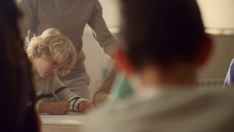 students making notes in exercise books at table. children doing class work