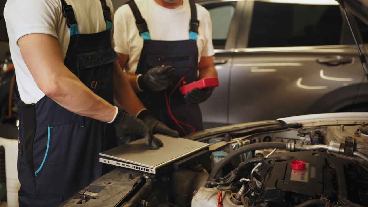 mecánicos de automóviles trabajando en un coche en un garaje