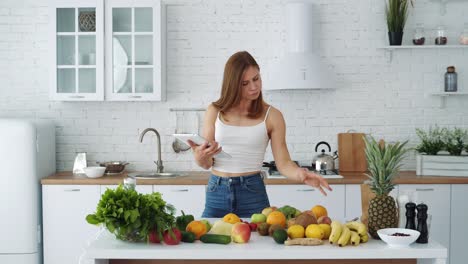 Young blogger woman preparing food, taking pictures on phone tablet for her social accounts or video stories. Weight loss and diet