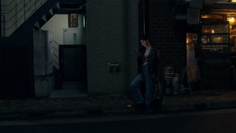 woman using smartphone at night in a city street