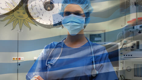 animation of flag of uruguay waving over female surgeon in operating theatre