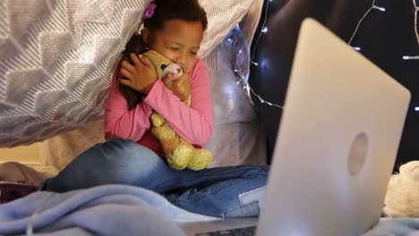 chica usando una computadora portátil en una cama en el dormitorio 4k