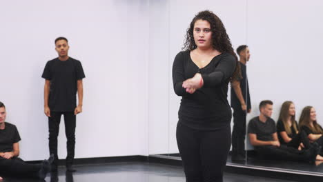 female dance student at performing arts school performs street dance for class in studio