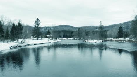 winter landscape - drone flying backwards over river - reveal - 4k