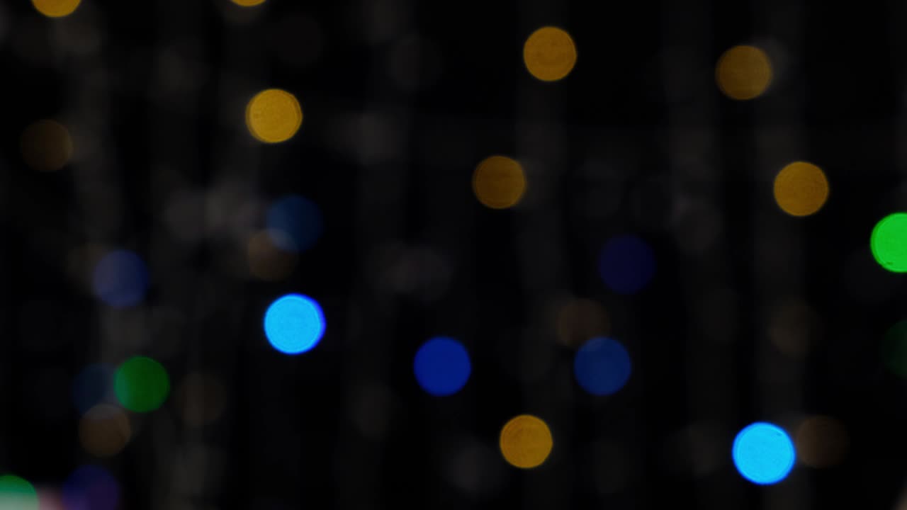 el parpadeo de linternas multicolores sobre un fondo negro. luces en la noche. confeti festivo.