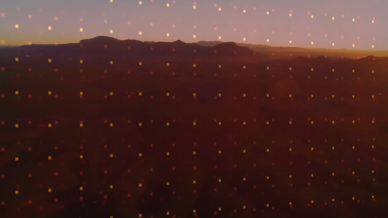 Glowing dots animating over mountain silhouette during sunset landscape scene