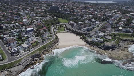 ocean wave rolling onto the shore of tamarama beach, cove beach and park in tamarama, nsw, australia