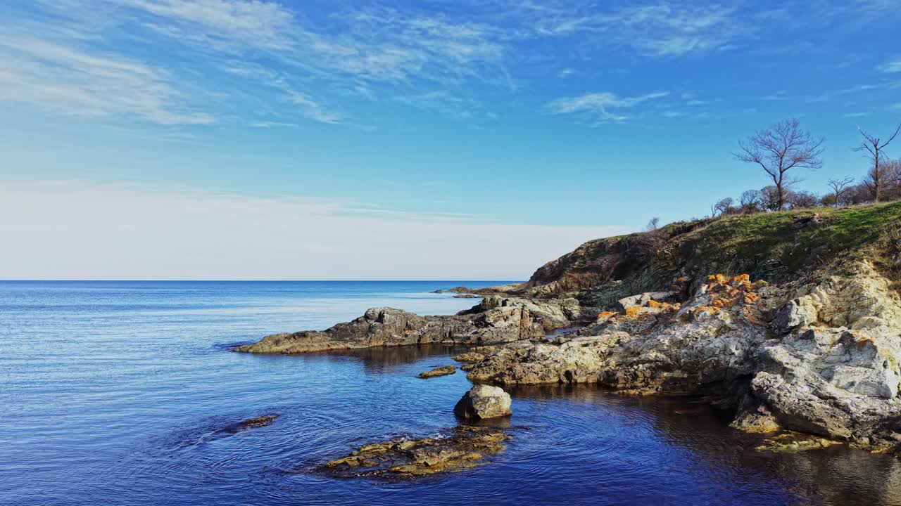 Scenic aerial view of coastal rocks and calm blue waters at daytime