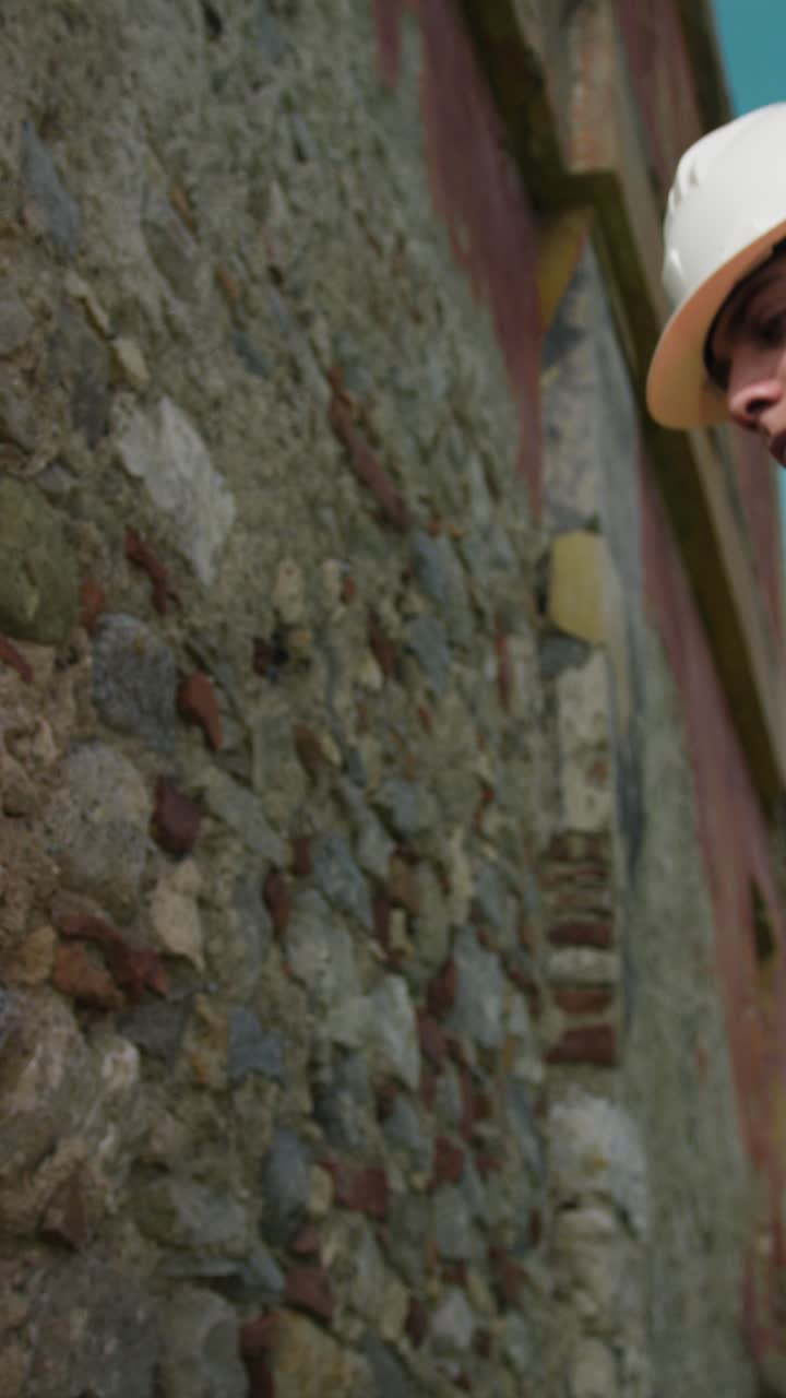 Construction Worker Measuring And Testing An Old Wall Outdoor
