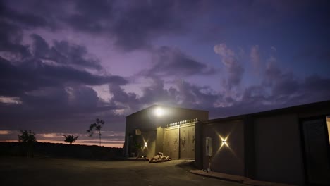 house facade illuminated during dramatic sunset. aerial pan right