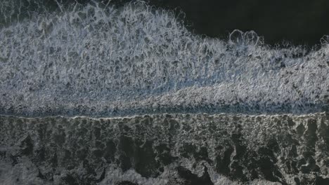 top down aerial view of sea water surface, white foam waves texture as natural background - aerial static