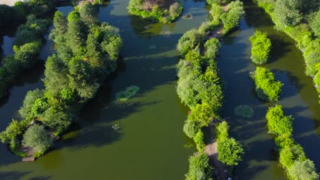 Tranquil-Pond-Popular-For-Fishing-In-Norfolk,-England---aerial-shot