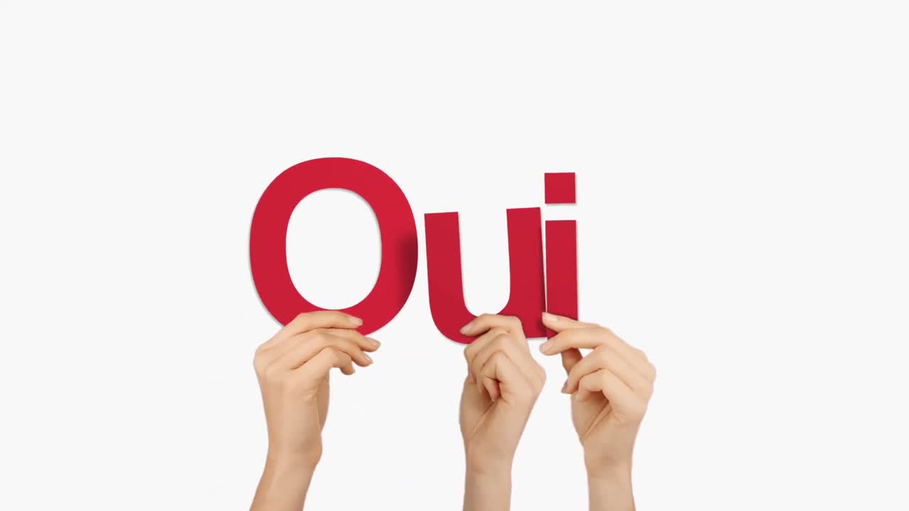 mujer con la mano sosteniendo las letras q, u e i