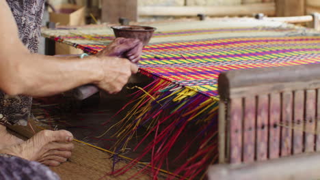 close up shot of hands cutting loose strands of a traditional mattress in quang nam province, vietnam